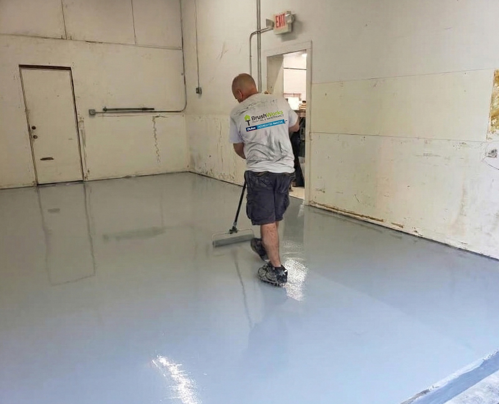 Painter applying coating to driveway surface